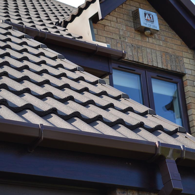 Close up image of roofline with brown upvc gutters